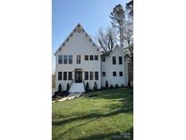 Stunning two-story home with black trim, beautiful landscaping, and a freshly manicured front lawn at 621 Poindexter Dr, Charlotte, NC 28209