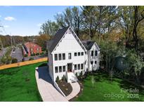 Beautiful, modern farmhouse with striking curb appeal, complemented by a lush green lawn and manicured landscaping at 621 Poindexter Dr, Charlotte, NC 28209