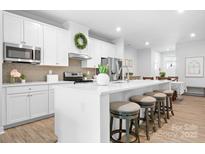 Stylish kitchen featuring a large island with seating, stainless appliances, and white cabinetry at 781 Hazel Way, Denver, NC 28037