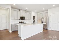 Bright kitchen features white cabinets, stainless steel appliances, and a large center island at 805 Blue Canyon Dr, York, SC 29745