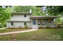 Charming two-story home featuring a blue front door, brick accents and inviting front porch at 917 Bobby Ln, Charlotte, NC 28211