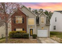 Charming two-story home featuring a mix of brick and siding, complemented by manicured shrubs and a well-maintained lawn at 10228 Seedling Ln, Charlotte, NC 28214
