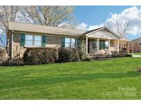 Charming brick home with a well-manicured lawn and inviting front porch perfect for relaxation at 108 Colonial Dr, Kings Mountain, NC 28086