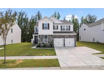 Beautiful two-story home featuring a two-car garage, well-manicured lawn, and stone and siding accents at 1195 Cavalier Ln, Rock Hill, SC 29730