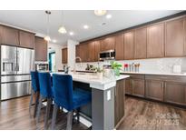 Stylish kitchen island with barstool seating, wood cabinetry, and modern lighting fixtures at 1195 Cavalier Ln, Rock Hill, SC 29730