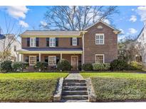 Charming two-story brick home with a well-manicured lawn and a stone pathway leading to the front door at 1626 Beverly Dr, Charlotte, NC 28207