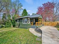 Charming home with a covered front porch, gray roof and a green exterior at 2501 Elkwood Cir, Charlotte, NC 28205