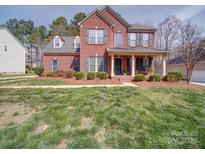 Charming two-story brick home with a covered porch and manicured lawn, perfect for Gathering living at 2538 Cherry Bark Oak Ct, Gastonia, NC 28056