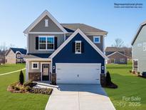 Charming two-story home featuring a gray and blue color scheme, a two-car garage, and a well-manicured lawn at 4465 Dusty Orchard Rd, Kannapolis, NC 28081