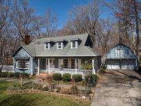 Charming blue two-story home with a welcoming front porch and a detached garage at 5410 Beaver Dam Ln, Mint Hill, NC 28227
