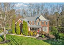 Beautiful two-story brick home with a manicured lawn and mature landscaping at 653 Buckleigh Nw Ct, Concord, NC 28027