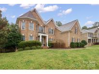 Traditional brick home with manicured lawn and detailed architectural features under a partly cloudy sky at 722 Fairway Point Dr, Fort Mill, SC 29708