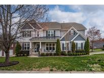 Charming two-story home with a well-manicured lawn and beautiful landscaping at 8941 Vickery Ln, Harrisburg, NC 28075