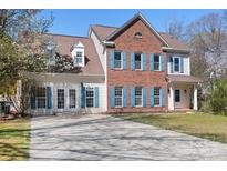 Charming two-story brick home featuring blue shutters, a well-manicured lawn, and a spacious driveway at 105 Easy St, Mooresville, NC 28117