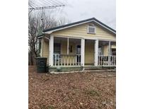 Quaint exterior featuring a porch with white railings and posts on a yellow home surrounded by bare trees at 1140 Mt Vernon Rd, Woodleaf, NC 27054