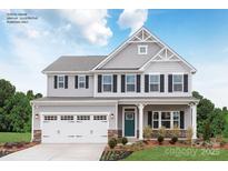 Charming two-story home with gray siding, white trim, black shutters and a two-car garage at 1240 Cottage Green Dr # 0132, Monroe, NC 28112