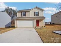 Two-story home with beige siding, a red door, an attached two-car garage, and a well-manicured front yard at 1542 Cannan Mountain Dr, Newton, NC 28658
