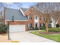 Charming two-story brick home with a well-manicured lawn and a two-car garage and basketball hoop at 215 Whitegrove Dr, Fort Mill, SC 29715