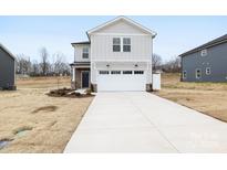 Charming two-story home featuring a white garage door, stone accents and a long driveway at 3030 Swallowtail Ln, Kannapolis, NC 28083