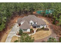 Stunning aerial view of home on a wooded lot with a tranquil pond at 4009 Beechwood Spring Ln, Belmont, NC 28012