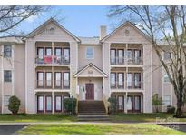 Multi-level condo with balconies, well-maintained landscaping, and brick stairway at 6142 Meadow Rose Ln, Charlotte, NC 28215