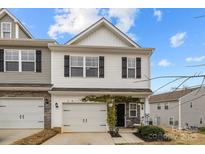 Charming two-story home with a one car garage, black shutters, and landscaped front yard at 7217 Somerford Rd, Charlotte, NC 28215