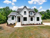 Striking exterior elevation of a new construction home, painted white with black trim and a well landscaped yard at 733 Barbary Pl, Lincolnton, NC 28092