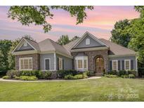 Charming single-story home featuring stone accents, manicured landscaping, and a warm, inviting entrance at 7913 Buena Vista Dr, Denver, NC 28037