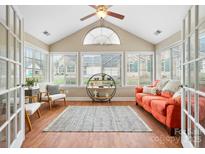 Bright sunroom with hardwood floors, lots of windows, vaulted ceilings, and a cozy seating arrangement at 824 Wynnshire Dr # D, Hickory, NC 28601