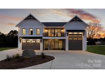 Modern farmhouse exterior with stone accents, two garage doors, and a welcoming front porch at 108 Isle Of Pines Rd # 3, Mooresville, NC 28117