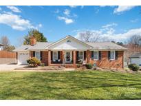 Charming brick home with a manicured lawn and welcoming front porch, perfect for relaxation and curb appeal at 1558 Pine Creek Rd, Gastonia, NC 28056