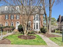 Charming brick home featuring a landscaped front yard and architectural details under a sunny sky at 227 Perrin Pl, Charlotte, NC 28207