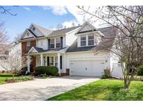 Charming two-story home featuring a well-manicured lawn, blossoming trees, and an attached two-car garage at 3329 Brownes Creek Rd, Charlotte, NC 28269