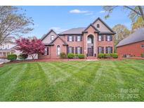 Charming two-story brick home with manicured lawn, mature trees, and classic architectural details, offering curb appeal at 3716 Drayton Hall Ln, Charlotte, NC 28270