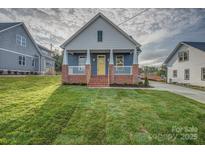 Charming home features a brick front porch with white columns and a bright yellow front door at 508 Standpipe Hl, Cramerton, NC 28032