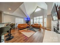 Bright living room featuring vaulted ceilings, two sofas, large windows, and modern decor at 513 N Graham St # 3H, Charlotte, NC 28202