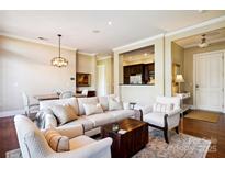 Open-concept living room featuring a cozy seating area, hardwood floors, and seamless flow into the dining space at 5425 Closeburn Rd # 309, Charlotte, NC 28210
