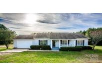 Charming single-story home with manicured lawn, inviting front porch, and attached garage at 9450 Paul Payne Store Rd, Stony Point, NC 28678