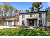 Charming two-story home with a well-manicured lawn and two-car detached garage at 10405 Club Car Ct, Mint Hill, NC 28227