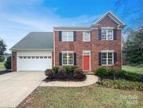 Charming two-story brick home with a red door, black shutters, and well-manicured landscaping at 1400 Wessex Ct, Monroe, NC 28110
