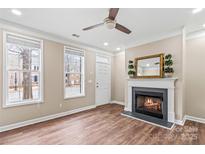 Inviting living room with a cozy fireplace and plenty of natural light from two large windows at 163 Singleton Rd, Mooresville, NC 28117