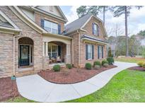 Charming brick home featuring an arched entryway and meticulously landscaped front yard at 303 Ridge Reserve Dr # 29, Clover, SC 29710