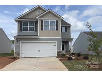 Charming two-story home featuring a two-car garage, gray siding and manicured landscaping at 3410 Saddlebred Dr, Gastonia, NC 28052