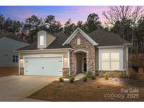 Charming single-Gathering home boasts stone accents, a two-car garage, and a welcoming front entrance at 4720 Maiden Creek Way, Maiden, NC 28650