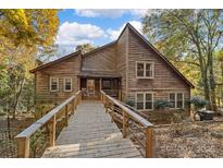 Charming wood home with a long, elevated walkway leading to the front porch at 5084 Mariana Ct, Tega Cay, SC 29708