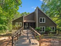 Charming home featuring a spacious wooden deck, beautiful landscaping, and a welcoming entrance at 5084 Mariana Ct, Tega Cay, SC 29708