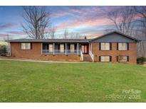 Charming brick home boasts a covered front porch and a spacious, well-manicured lawn at 822 Bethlehem Rd, Kings Mountain, NC 28086