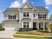 Charming two-story home with gray siding, black shutters, and a well-manicured front yard at 924 Stebbins Dr, Fort Mill, SC 29715