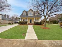 Charming two-story home with a well-manicured lawn, inviting walkway, and classic architectural details at 104 Tarrington Dr, Statesville, NC 28625