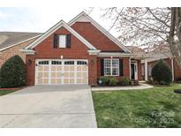 Charming red brick home with a well-manicured lawn and attached two car garage at 10911 Round Rock Rd, Charlotte, NC 28277